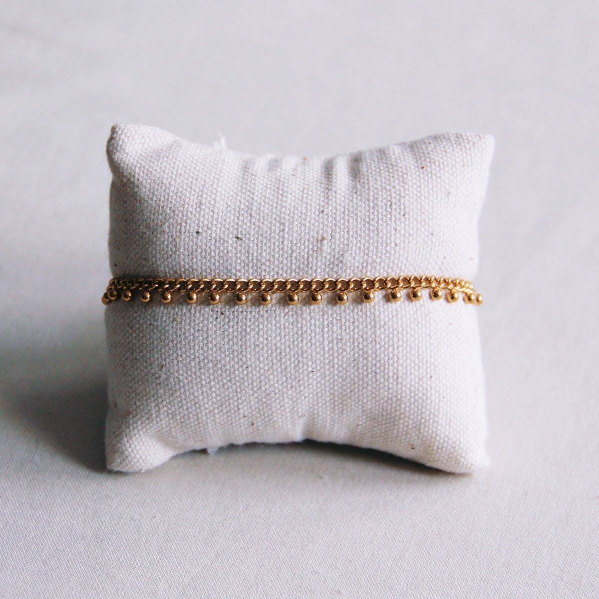 Stalen schakelarmband met balletjes - goud