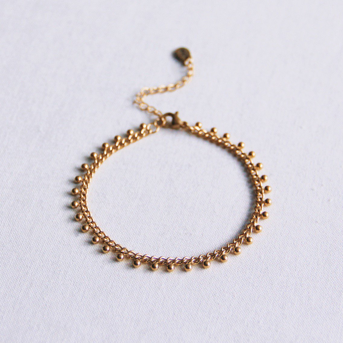 Stalen schakelarmband met balletjes - goud
